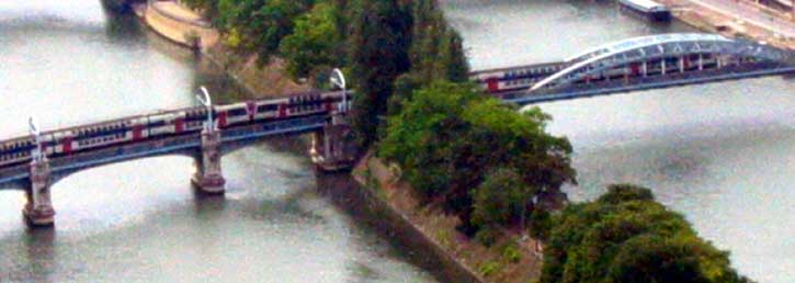 27.07.2003.  по мосту над Сеной идёт двухэтажный поезд линии RER-С. Система RER-пригородные поезда с верхним токосьёмом, в центре города ходящие под землей.  (23 kb.)